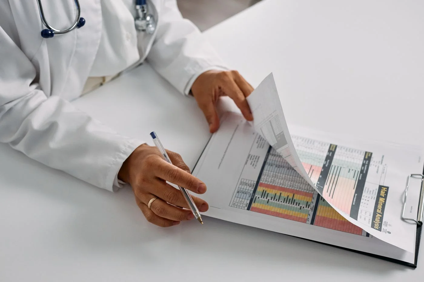 Close-up of a clinician reviewing a chart and writing notes